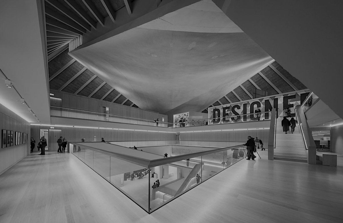 The atrium of the Design Museum in London, under its curved timber roof.